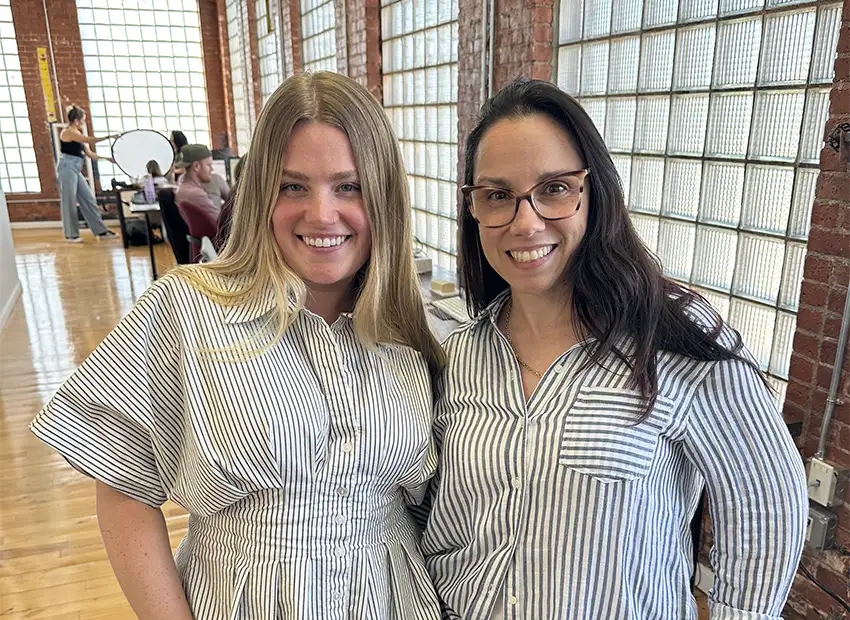 Talia and Danielle smiling in an office hallway