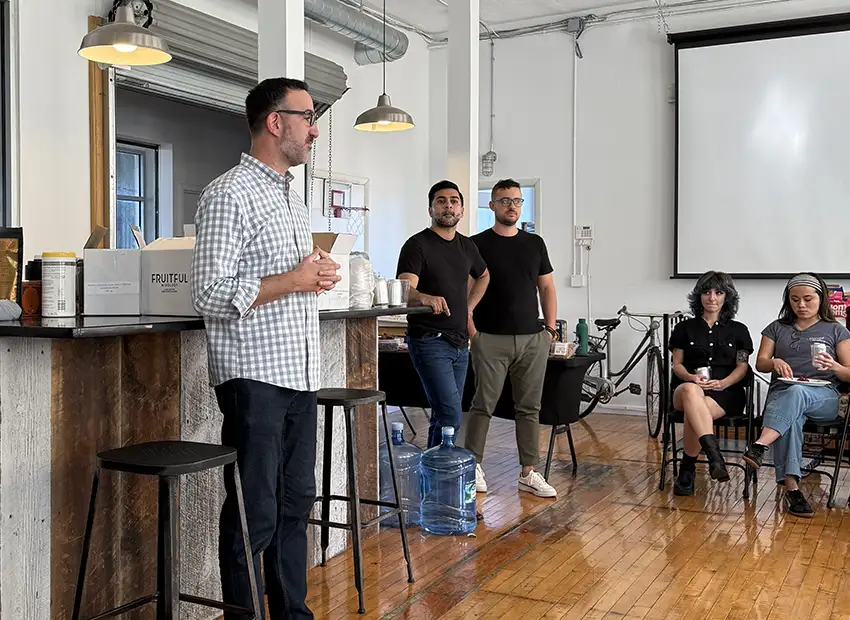 Chad talking infront of the room to introduce the Fruitful creators while GO members sit in chairs listening