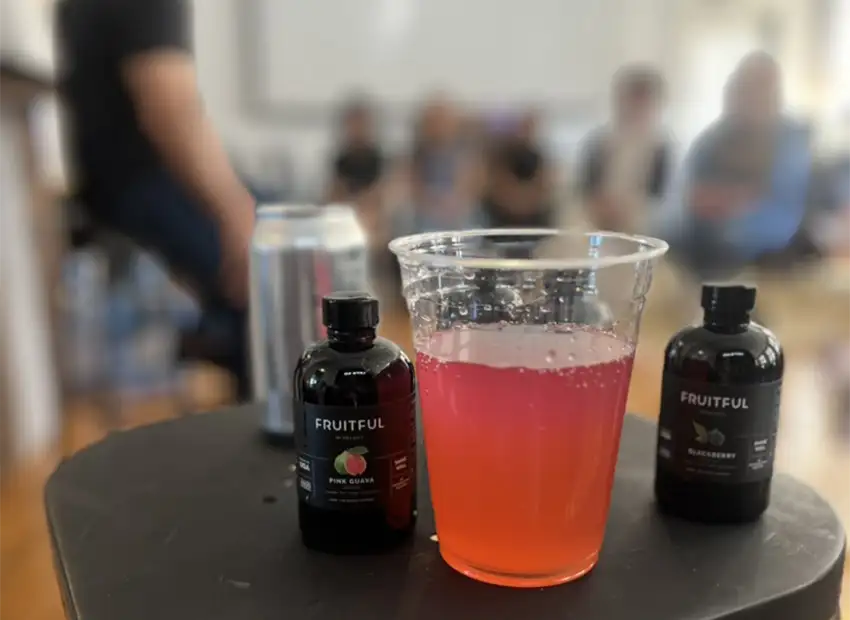 Close up of Fruitful bottles and a pink drink in a cup
