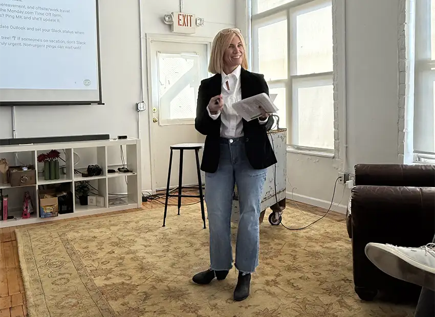 MK talking at the front of the room with a projector behind her